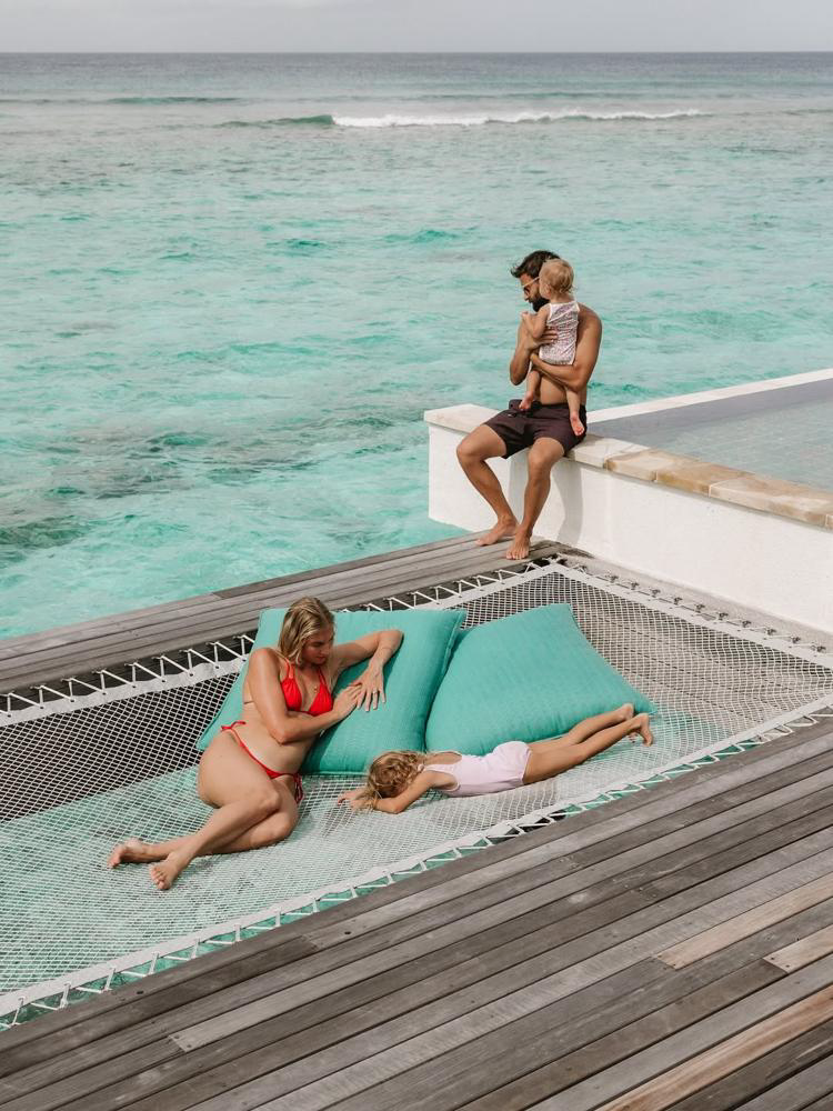 A family relaxing over the ocean at Six Senses Kanuhura