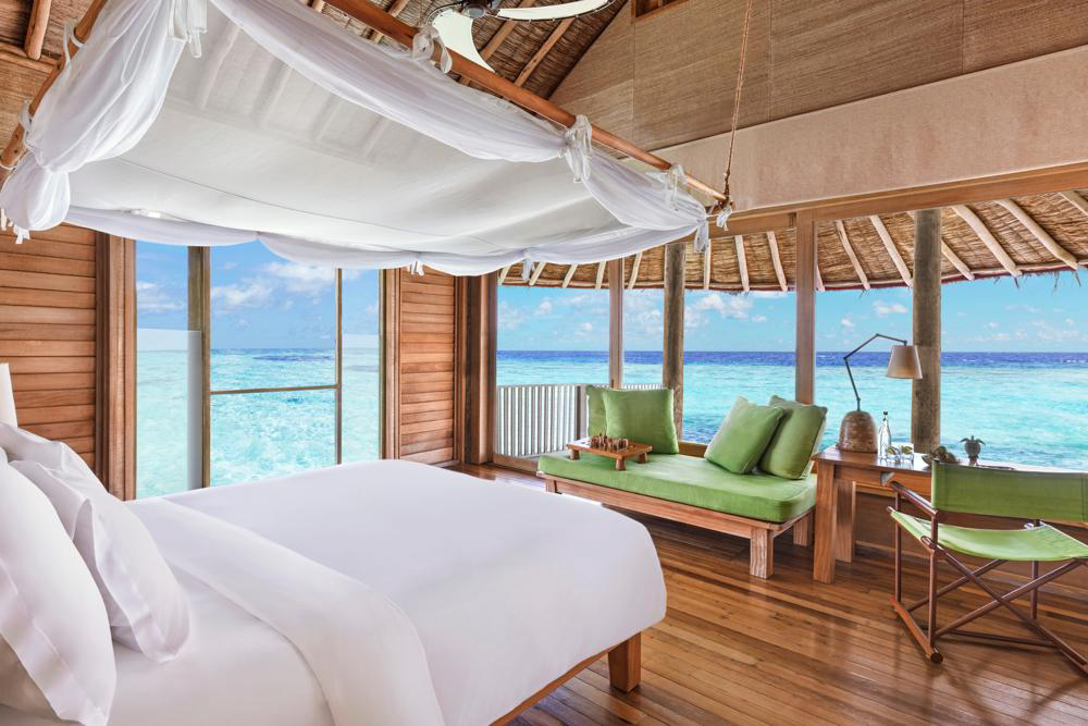 Overwater villa bedroom looking towards the lagoon at Six Senses Laamu