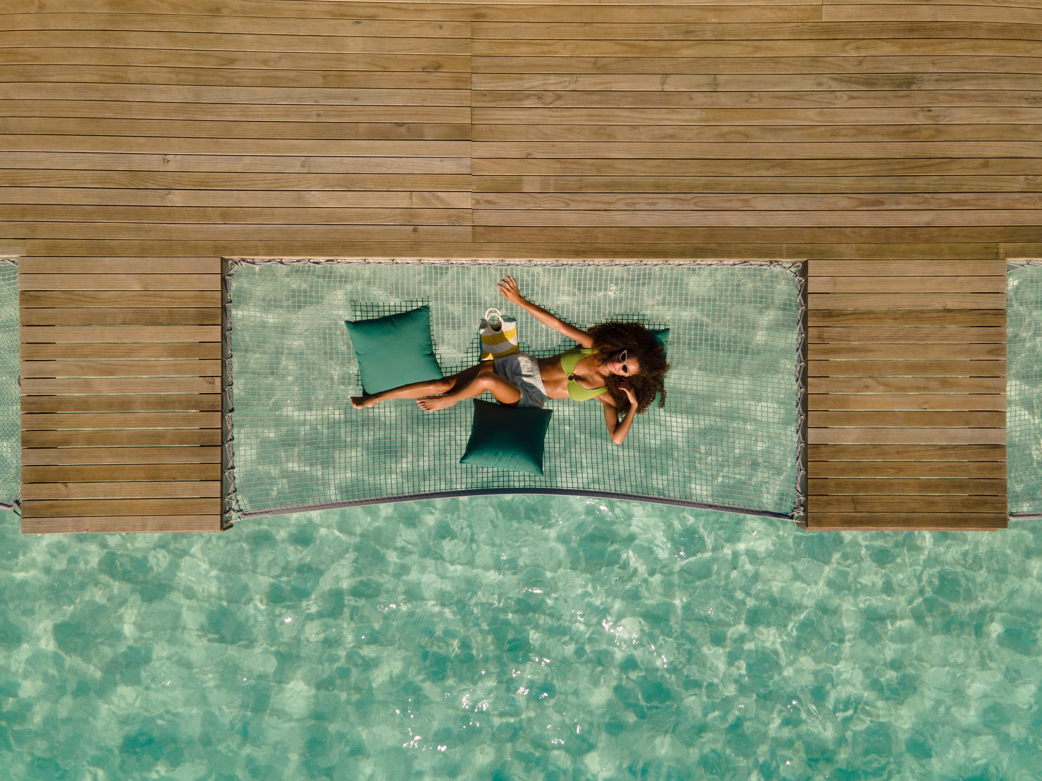 Overwater villa hammock above lagoon water at Sun Siyam Vilu Reef